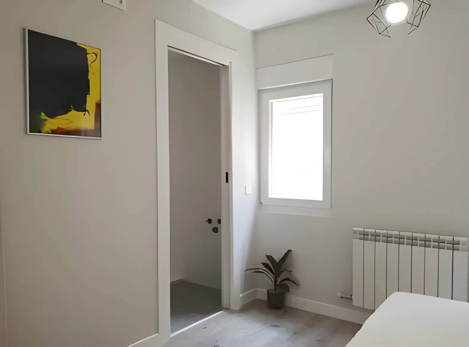 Habitación recién pintada en blanco por Los Pintores Ávila para comunidad de vecinos